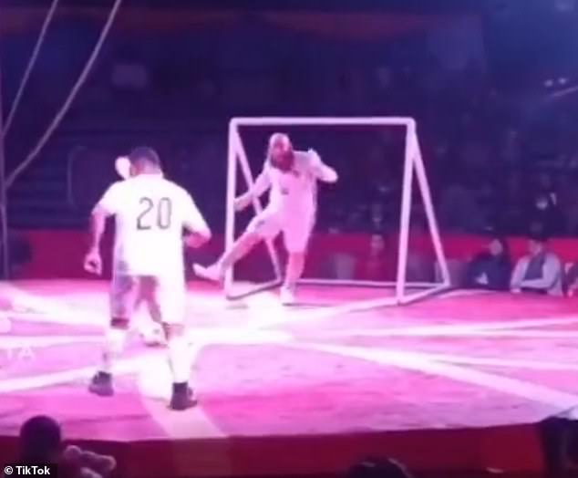 A circus star impersonates Redmayne's trademark dancing during penalty shootouts as a striker prepares to take a shot - only for the fake Socceroo to literally move the goalposts